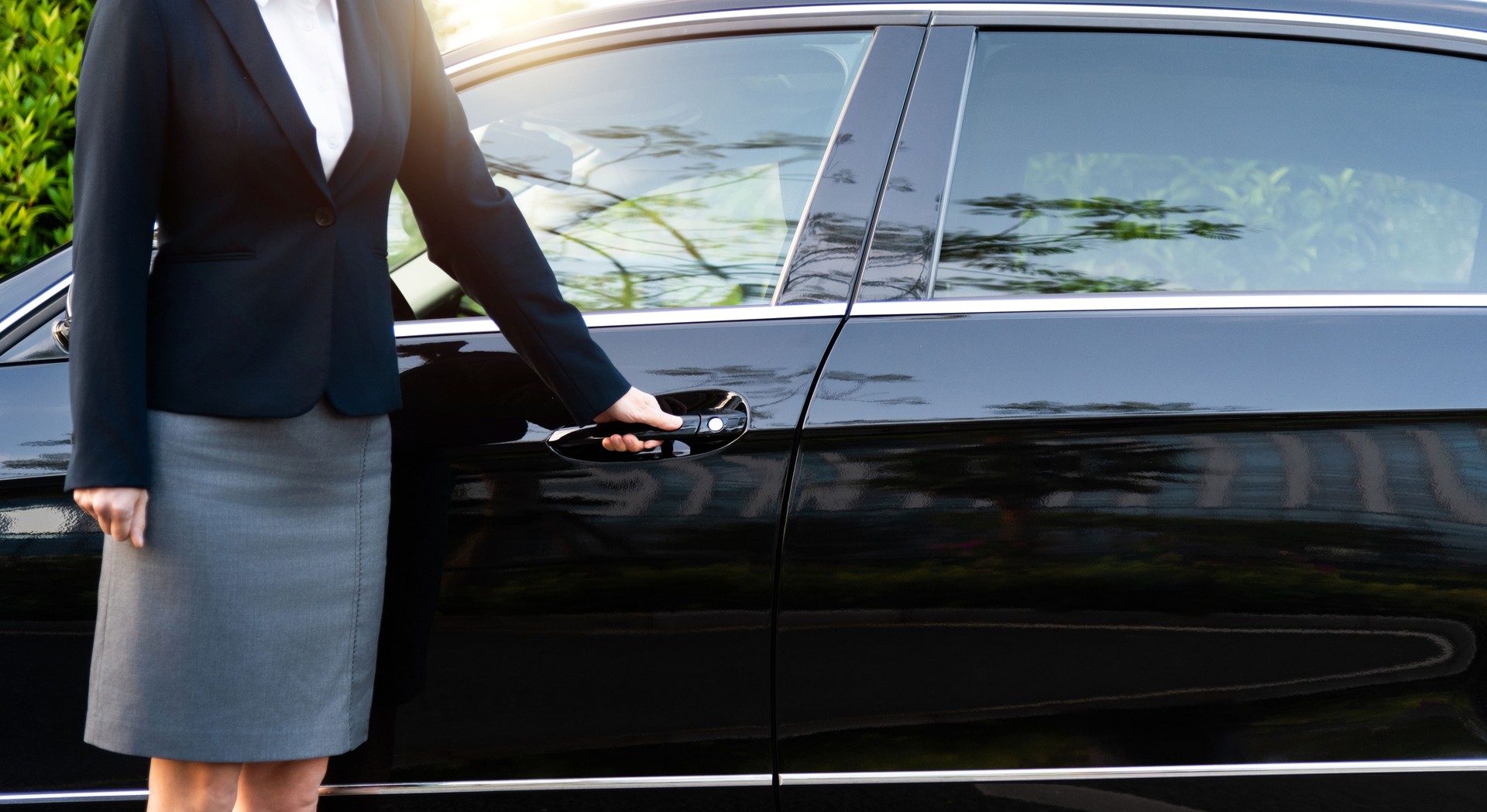 Well dressed woman opening a car door