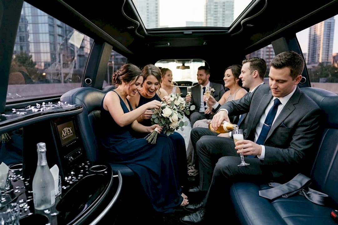 Wedding party relaxing inside limousine