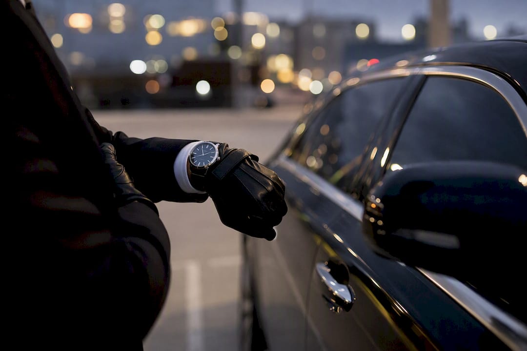 Chauffeur’s hand checking watch near limo